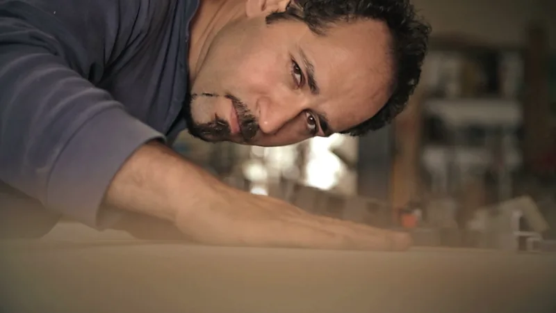 Antoun Fahmeh passe la main sur une planche pour en contrôler la surface