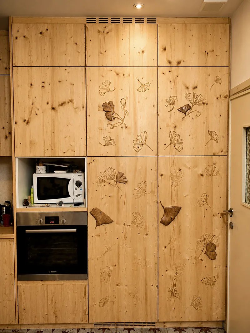 Mur de rangement de cuisine en bois massif gravé de feuilles de ginkgo, avec four encastré