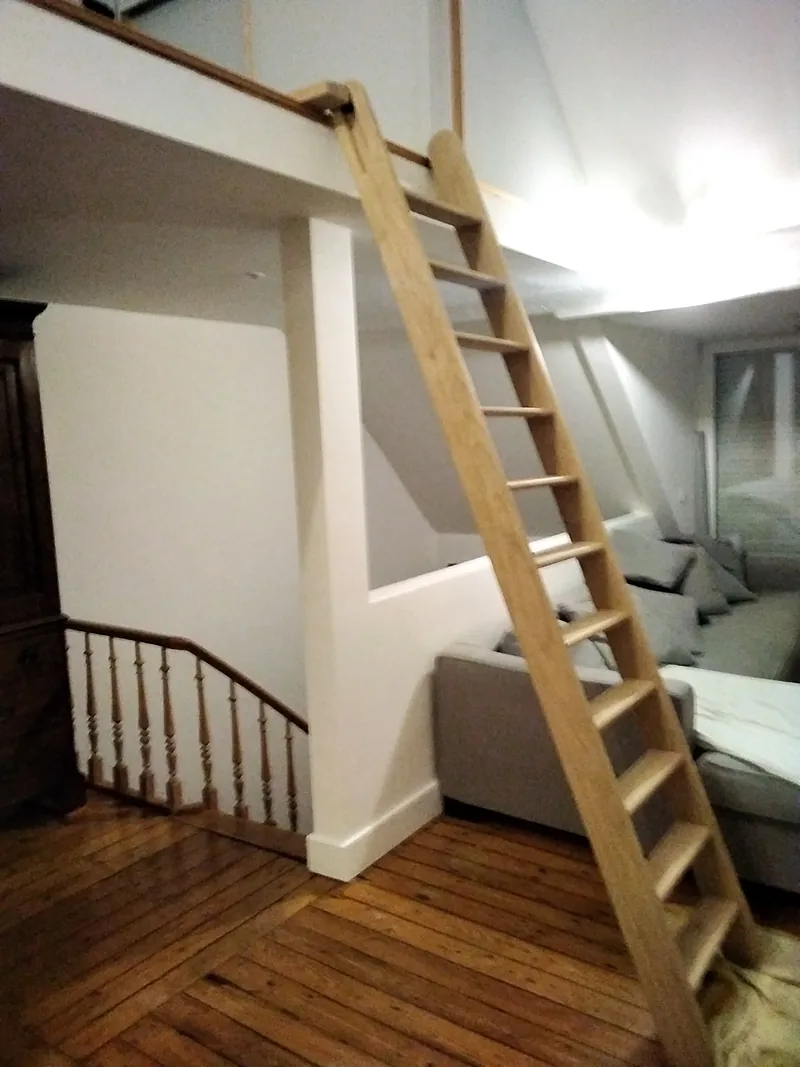 Échelle de meunier en bois menant à une mezzanine