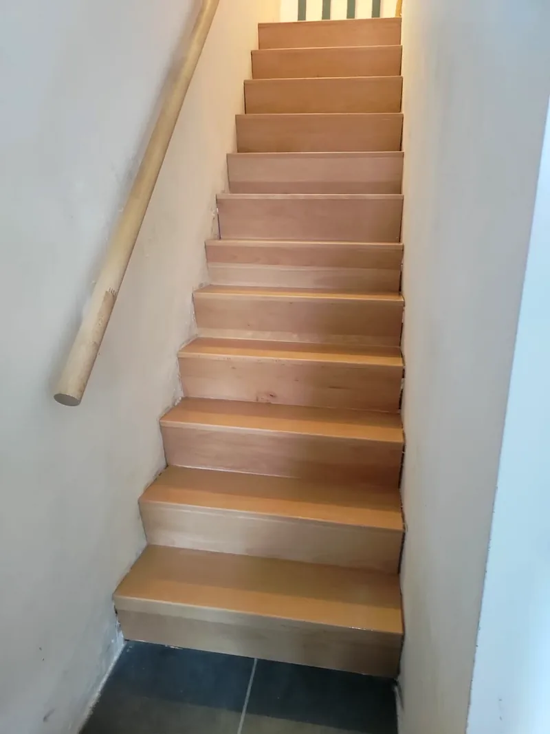 Escalier droit en bois entre deux murs, avec main courante ronde