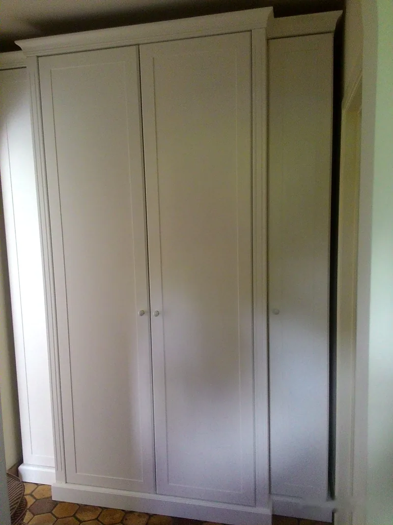 Garde-robe classique blanche à portes moulurées et corniche