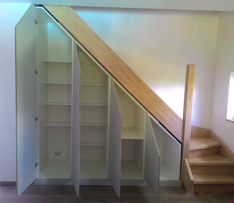 Placards sous escalier ouverts : étagères et penderie ajustées à la pente