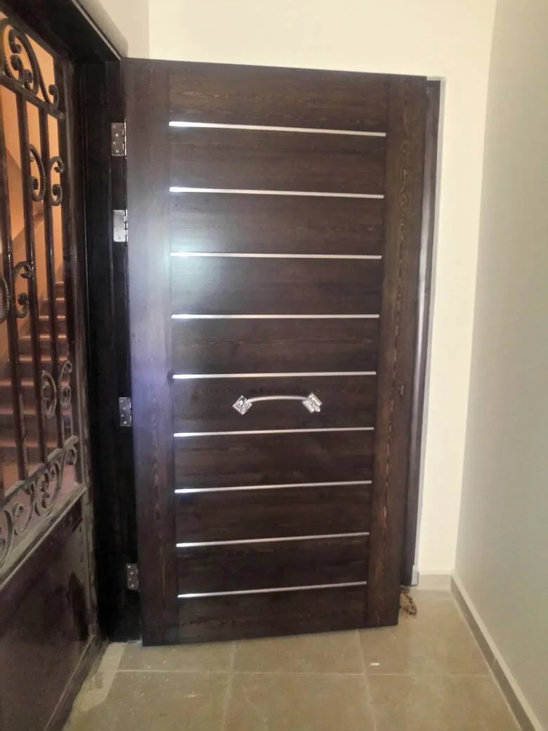 Porte en bois foncé à filets métalliques horizontaux