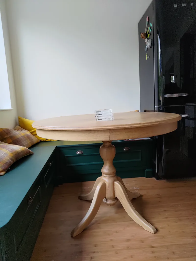 Table ronde en bois massif à pied central tourné, dans un coin repas