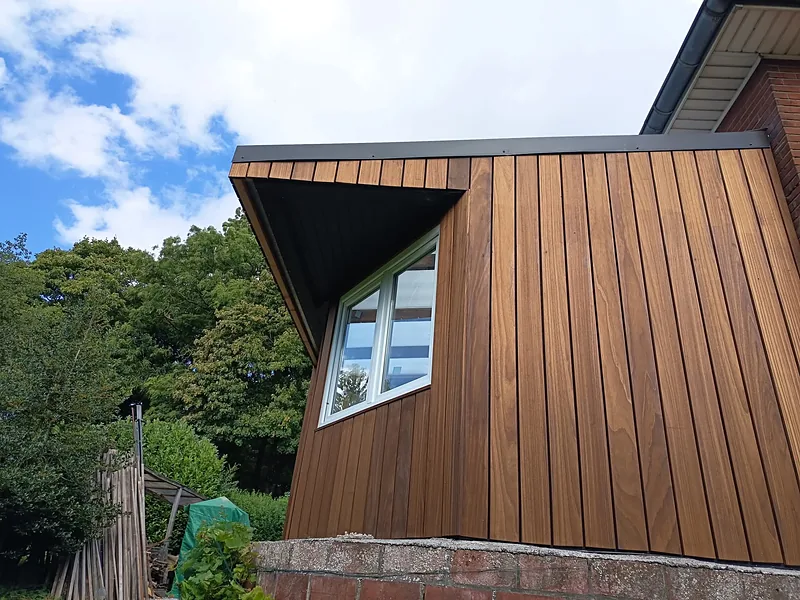 Angle d'une véranda en bois avec fenêtre sous le débord de toit